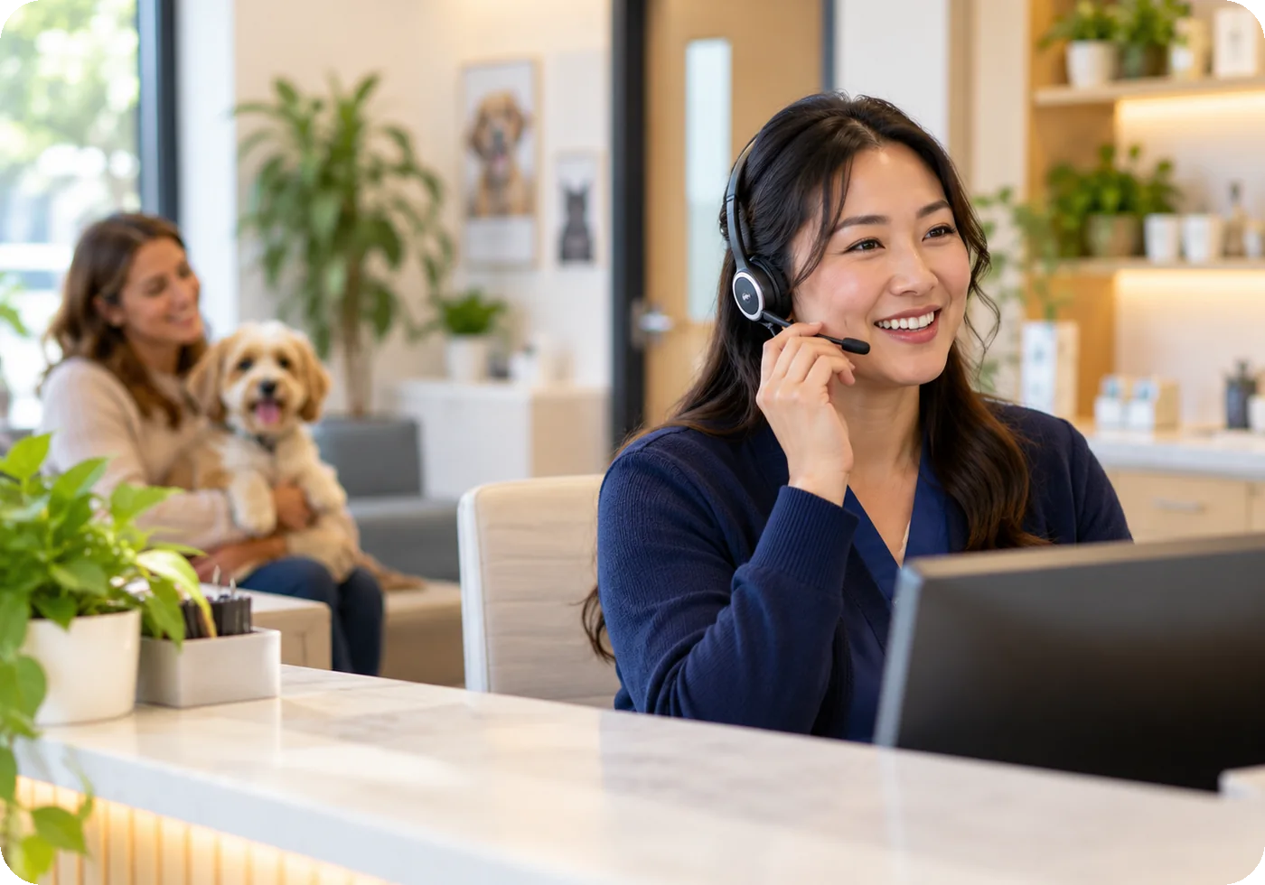 A receptionist with a headset answering a call at a clinic front desk
